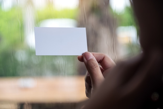 Woman holding and showing an empty business card 