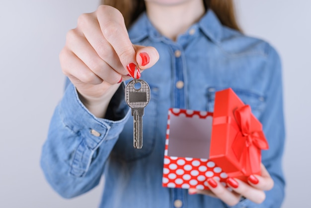 Woman holding silver metal key and open giftbox