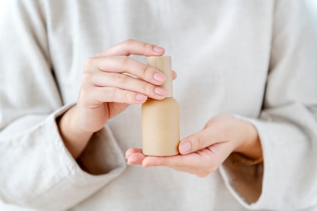 Woman holding a skin foundation bottle