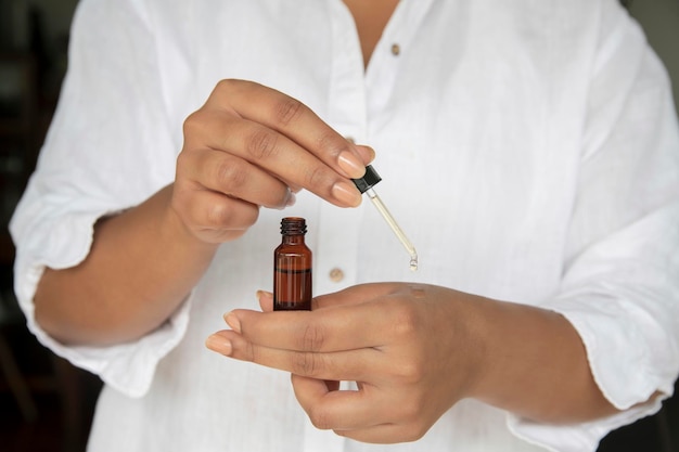 A woman holding a small bottle of essential oil