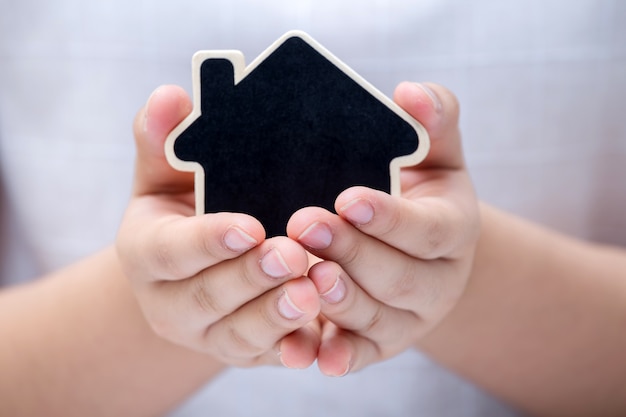 Woman holding the small home.  Concept for real estate business.