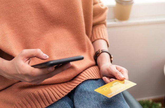 Фото Женщина, держащая смартфон и кредитную карту.