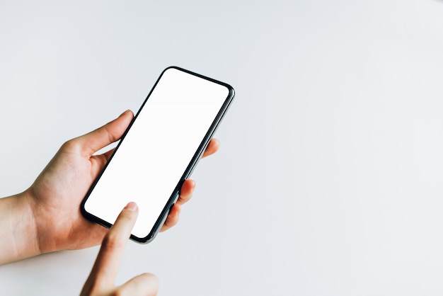 Woman holding smartphone mockup of blank screen on the table.