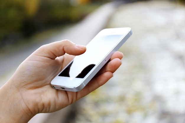 Woman holding smartphone outside