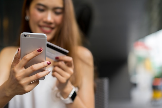 woman holding smartphone with credit card for pay online shopping