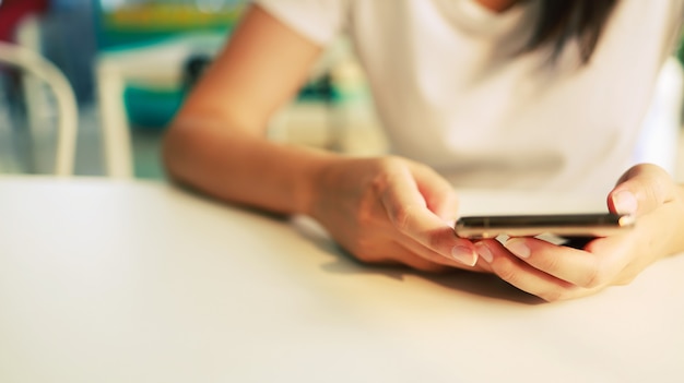 Woman holding SmartphoneÂ working mobile devices. cell telephone technology e-commerce concept.