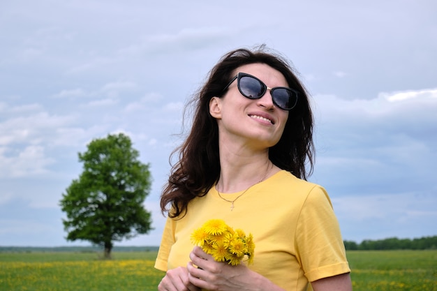 Woman holding some yellow flowers