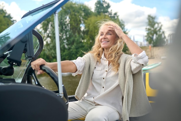 Woman holding a steering wheel of the boat and looking concentrated