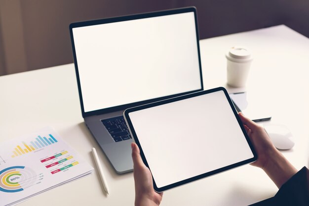 Woman holding tablet screen blank and laptop on the table  to promote your products.  of future and trend internet for easy access to information.