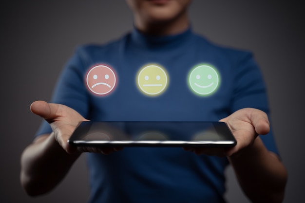 Woman holding tablet and show emoticon hologram effect