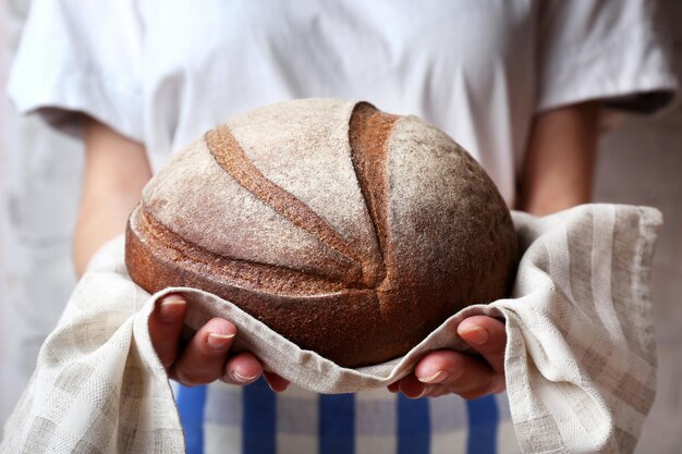 Woman holding tasty fresh bread close up