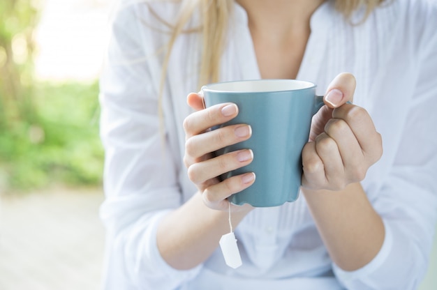 お茶のマグを保持している女性