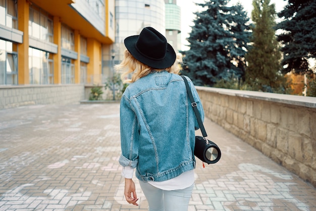 woman holding a technological portable compact boombox on shoulder