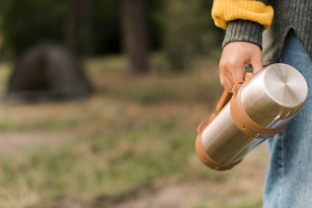 Photo woman holding thermos while camping with copy space