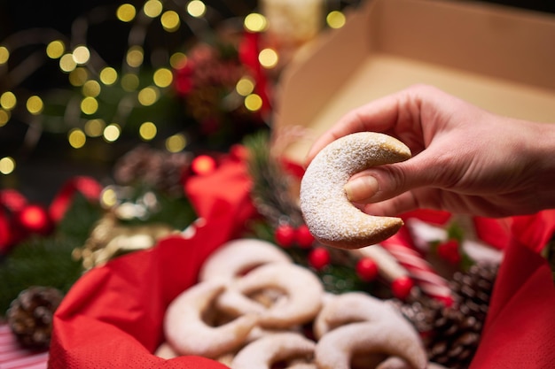 Woman holding traditional german or austrian vanillekipferl vanilla kipferl cookie