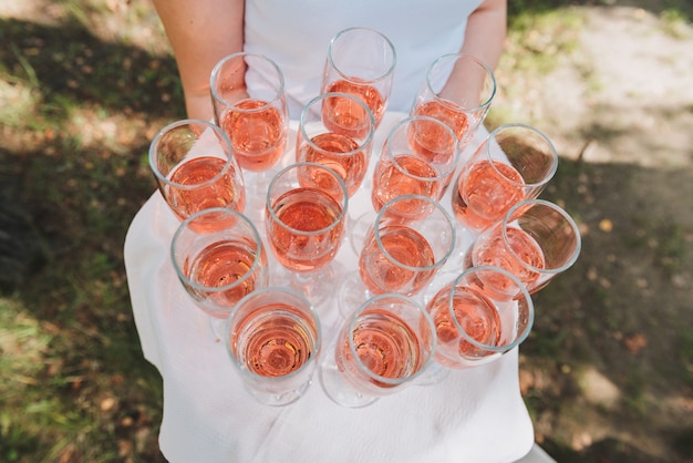 Woman holding a tray of glasses of rose sparkling wine