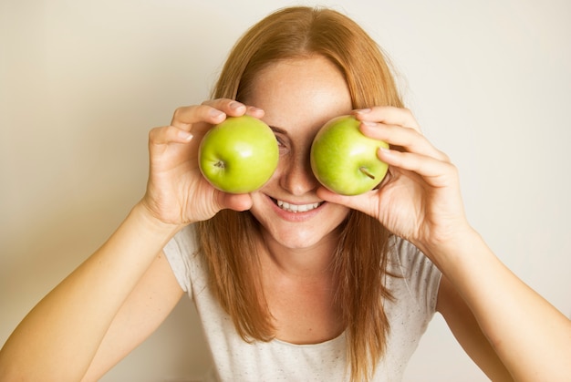 Woman holding two green apples.