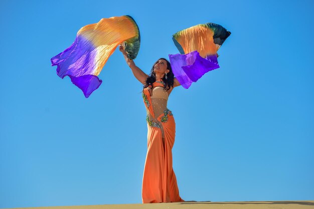 Woman holding umbrella against blue sky