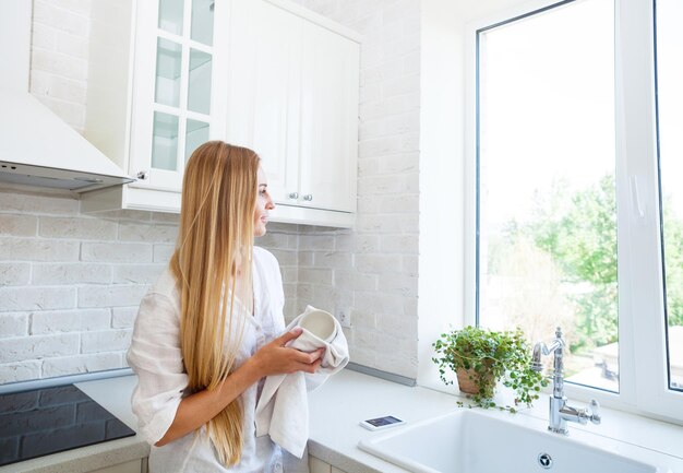 Woman holding umbrella against window