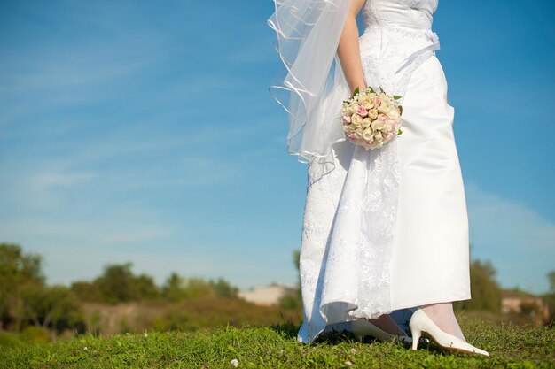 Photo woman holding umbrella on grassy field against blue sky