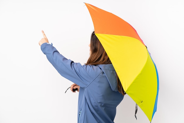 Woman holding an umbrella over isolated wall