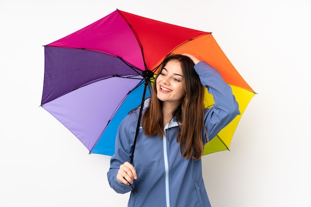笑っている白い壁に分離された傘を保持している女性