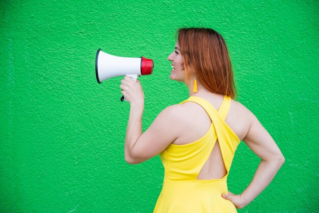 Photo woman holding umbrella standing against green wall