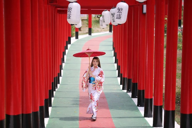 Woman holding umbrella standing outdoors in temple