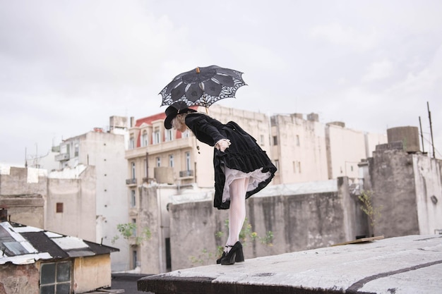 Photo woman holding umbrella while standing on terrace