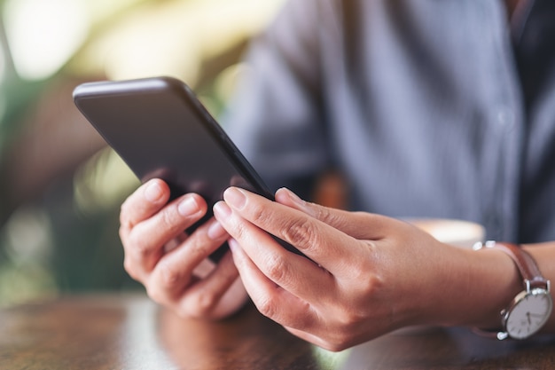 a woman holding , using and looking at smart phone