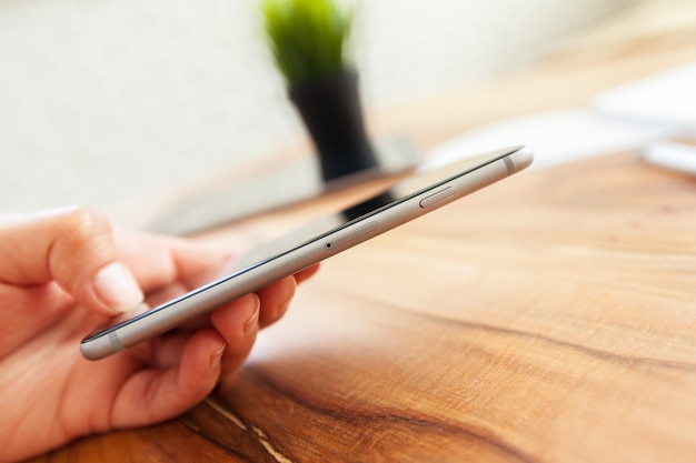 A woman holding and using the smart phone