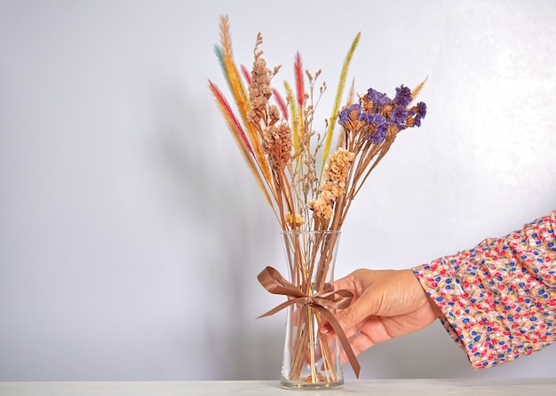 Foto donna che mantiene un vaso con fiori secchi