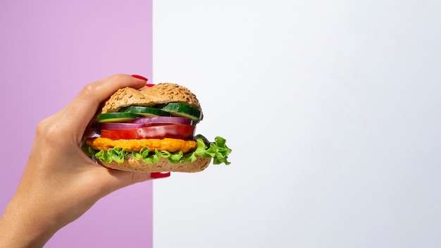 Foto donna che tiene un hamburger di verdure in sua mano