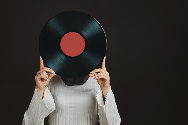 Photo woman holding vinyl record music passion listening to music from analog record playing music from