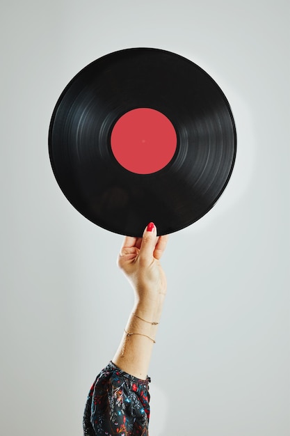 Foto donna con un disco in vinile passione per la musica ascoltando musica da un disco analogico festa di musica retrò