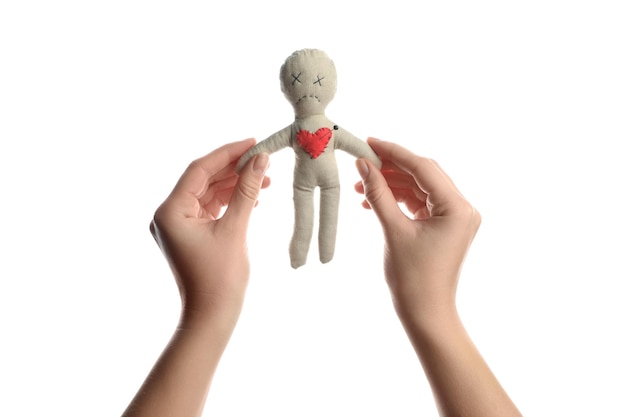 Photo woman holding voodoo doll with pin in heart on white background closeup