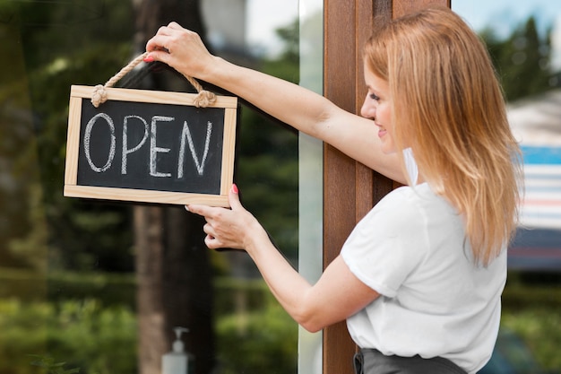 Photo woman holding we are open sign