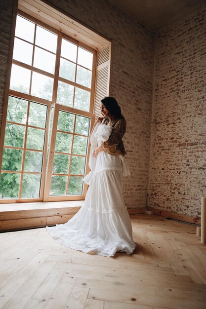 Woman holding wedding dress while standing at home