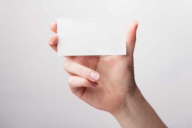 Woman holding a white business card in his hand, close up