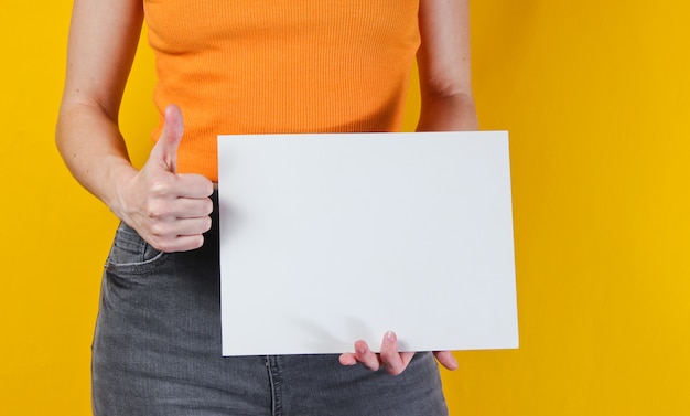 Woman holding white empty sheet of paper