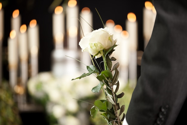 Photo woman holding white flower at funeral