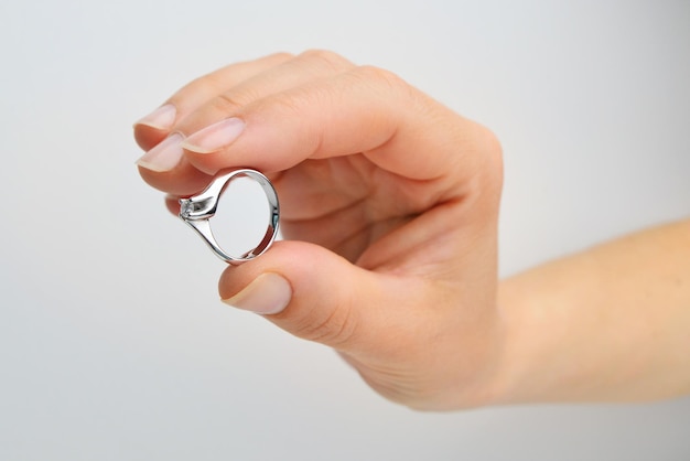 Woman holding a white gold ring with diamond