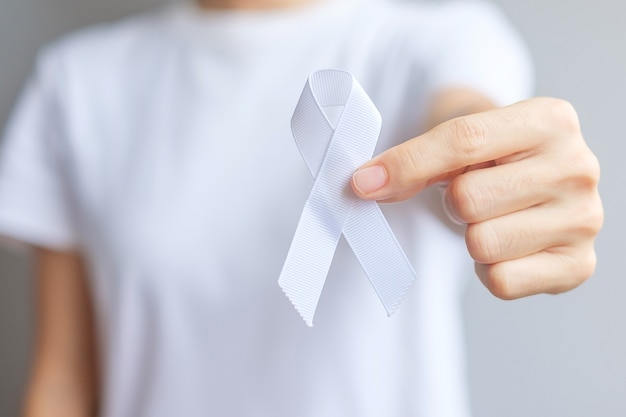 Woman holding white Ribbon for November Lung Cancer Awareness month, democracy and international peace day. Healthcare concept