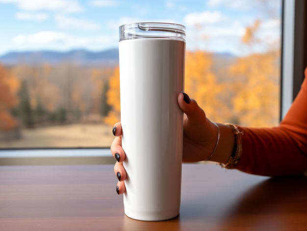 Photo a woman holding a white travel mug with a mountain landscape in the background