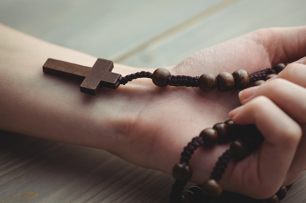 Woman holding wooden rosary beads 