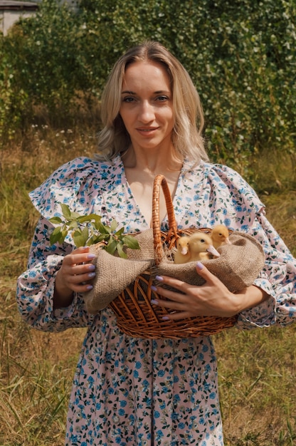 Woman holding yellow ducklings in a basket