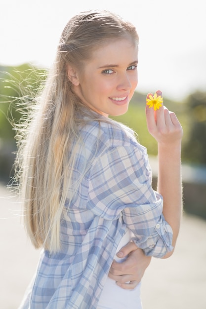 Woman holding yellow flower in hand