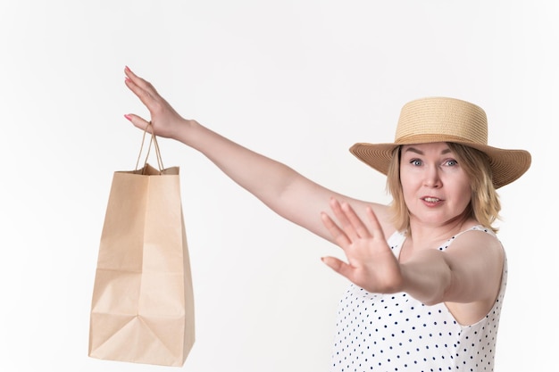 Foto la donna tiene la borsa per lo shopping in mano distesa sul lato allungato del segnale di stop in avanti della seconda mano