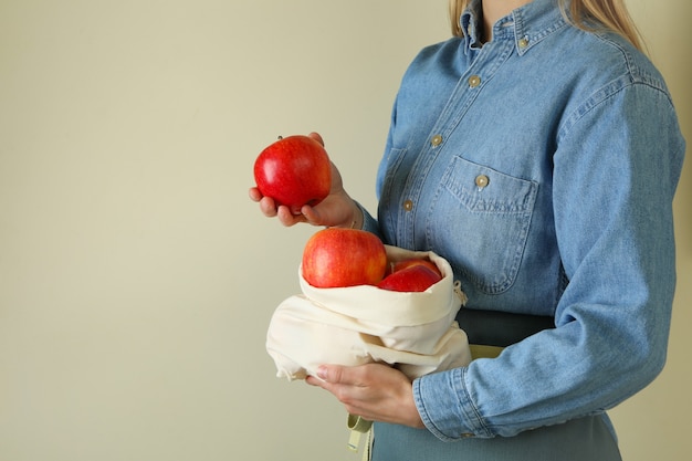 Woman holds bag with ripe red apples