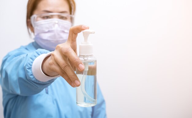 Woman holds a bottle of alcohol gel in her hand for frequently cleaning hands and prevent coronavirus infection